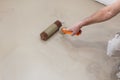 Repair work. Pouring floors in the room. Fill screed floor repair and furnish. Worker align cement with roller Royalty Free Stock Photo