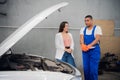 A repairer asks a customer about a car repair Royalty Free Stock Photo