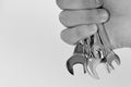 Repairer or mechanic hand holds spanner instrument. Set of wrench tools in male hand on white background