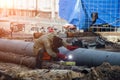 Repairing of city water supply or sewer pipeline. Worker is welding pipe