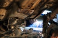 Welder welds silencer on car by argon welding