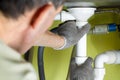 Repairing a drain pipe in the kitchen under the sink. Royalty Free Stock Photo
