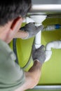 Repairing a drain pipe in the kitchen under the sink. Royalty Free Stock Photo