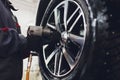 Repairman balances the wheel and installs the tubeless tire of the car on the balancer in the workshop.