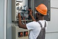 Repairman checking cables in power transformer at solar farm Royalty Free Stock Photo