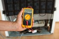 Repairman Checking Fridge With Digital Multimeter Royalty Free Stock Photo