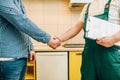 Repairman and customer shake hands, handyman Royalty Free Stock Photo