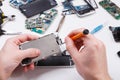 Repairman disassembling phone with screwdriver Royalty Free Stock Photo