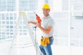 Repairman with drill machine climbing ladder in building Royalty Free Stock Photo