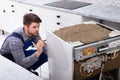 Repairman Fixing Dishwasher With Digital Multimeter Royalty Free Stock Photo