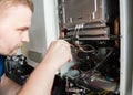 Repairman fixing a gas water heater with a screwdriver Royalty Free Stock Photo