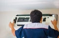 Repairman fixing modern air conditioner, Male technician cleaning air conditioner indoors, Maintenance and repairing concepts Royalty Free Stock Photo