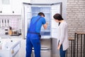 Repairman Fixing Refrigerator With Screwdriver Royalty Free Stock Photo