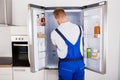 Repairman Fixing Refrigerator