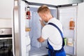 Repairman Fixing Refrigerator