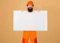 Repairman in hard hat with advertising banner. Happy Construction worker in protective helmet shows blank sign board.