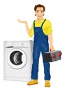 Repairman holding a toolbox and posing next to a washing machine showing something