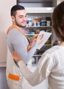 Repairman and housewife at kitchen Royalty Free Stock Photo