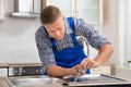 Repairman Installing Faucet Of Kitchen Sink