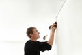 Repairman installing white stretch ceiling