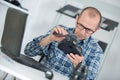 Repairman looking at camera through magnifying glass