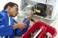 Repairman makes refrigerator appliance troubleshooting and maintenance