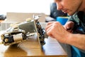 Repairman master is testing old disassembles sewing machine in workshop repairing it sitting at table Royalty Free Stock Photo