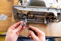 Repairman master is testing old disassembles sewing machine in workshop repairing it sitting at table Royalty Free Stock Photo