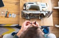 Repairman master is testing old disassembles sewing machine in workshop repairing it sitting at table Royalty Free Stock Photo