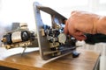 Repairman master is testing old disassembles sewing machine in workshop repairing it sitting at table Royalty Free Stock Photo