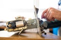 Repairman master is testing old disassembles sewing machine in workshop repairing it sitting at table Royalty Free Stock Photo