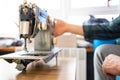 Repairman master is testing old disassembles sewing machine in workshop repairing it sitting at table Royalty Free Stock Photo