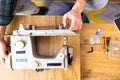 Man is looking inside sewing machine trying to repair it, hands closeup. Royalty Free Stock Photo