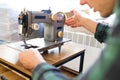 Repairman master is testing old disassembles sewing machine in workshop repairing it sitting at table Royalty Free Stock Photo