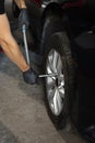 Repairman mounting wheel tire at service station. Car mechanic replacing a car wheel tire in garage workshop. Auto Royalty Free Stock Photo