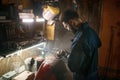 Repairman polishing motorcycle body part from old paint using stripping machine