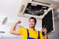 The repairman repairing ceiling air conditioning unit