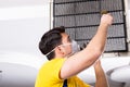 The repairman repairing ceiling air conditioning unit