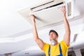 The repairman repairing ceiling air conditioning unit