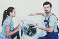 Repairman is repairing a washing machine for housewife. White background Royalty Free Stock Photo