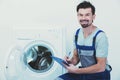 Repairman is repairing a washing machine on the white background Royalty Free Stock Photo