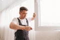 a repairman repairs, adjusts or installs metal-plastic windows in the apartment. Royalty Free Stock Photo