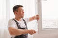 a repairman repairs, adjusts or installs metal-plastic windows in the apartment. Royalty Free Stock Photo