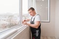 a repairman repairs, adjusts or installs metal-plastic windows in the apartment. Royalty Free Stock Photo