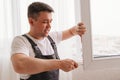 a repairman repairs, adjusts or installs metal-plastic windows in the apartment. Royalty Free Stock Photo