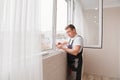 a repairman repairs, adjusts or installs metal-plastic windows in the apartment. Royalty Free Stock Photo