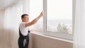 a repairman repairs, adjusts or installs metal-plastic windows in the apartment. Royalty Free Stock Photo