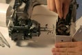 Repairman testing disassembles sewing machine in workshop repairing it. Royalty Free Stock Photo