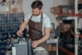Repairman in uniform checking coffee machine in own workshop Royalty Free Stock Photo
