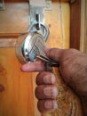 A repairman unlocking the lock with holding in dirty hand key at door opening Royalty Free Stock Photo